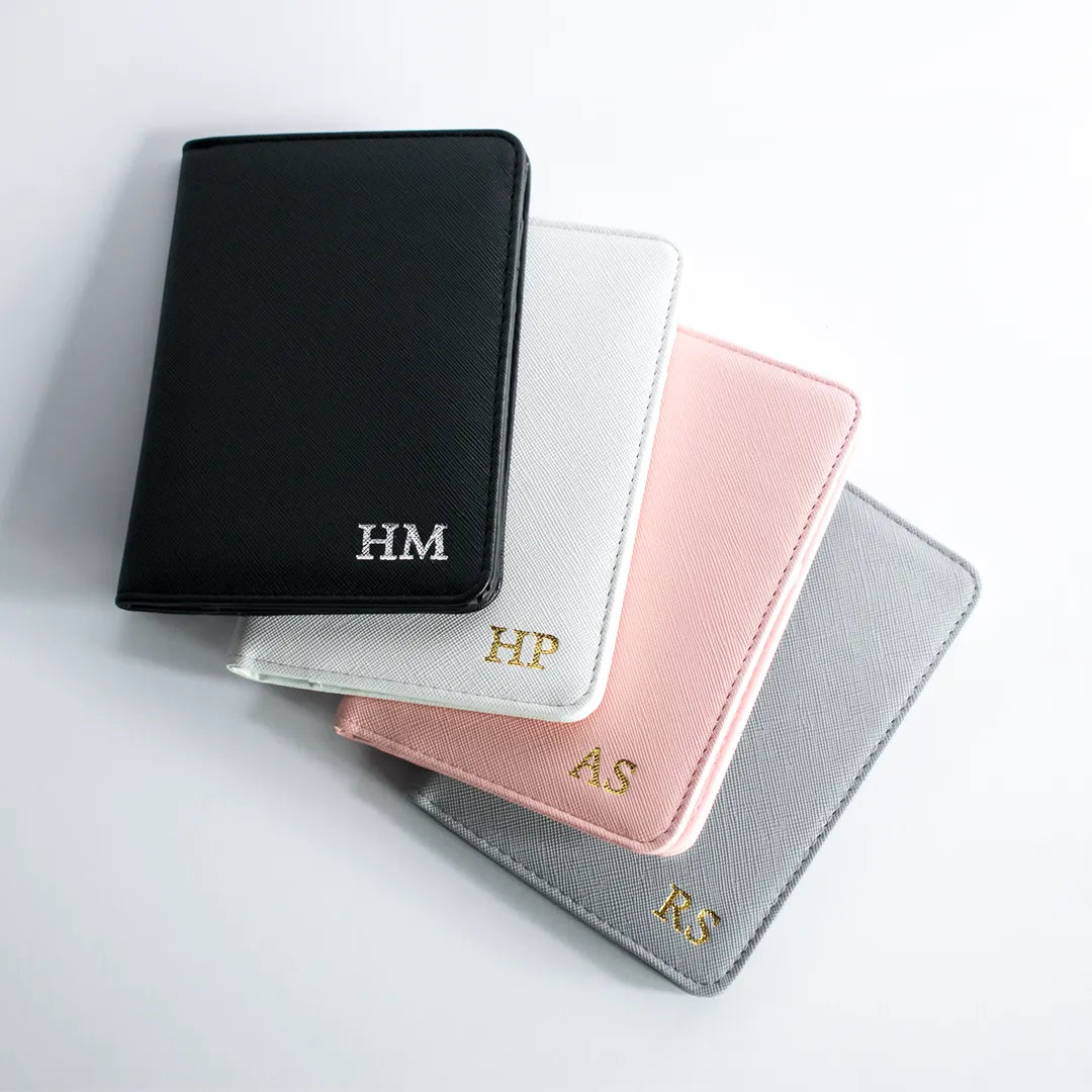 Personalized leather passport holder in four colors: black, white, pink, and gray. Customizable with your logo or name for a stylish and durable travel accessory